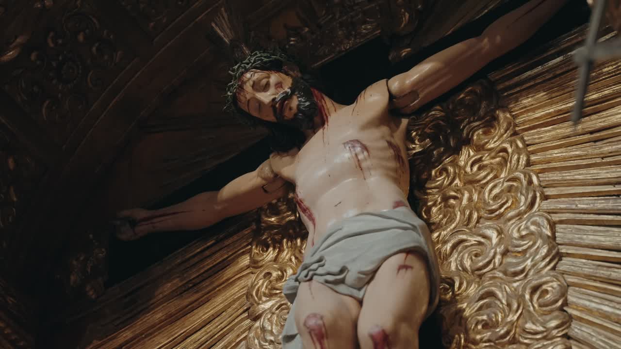 Scultura barocca dettagliata di Gesù Cristo crocifisso su sfondo dorato