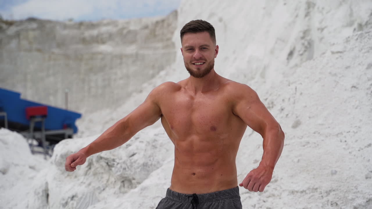 Good looking bodybuilder posing. Sexy view of handsome topless male model