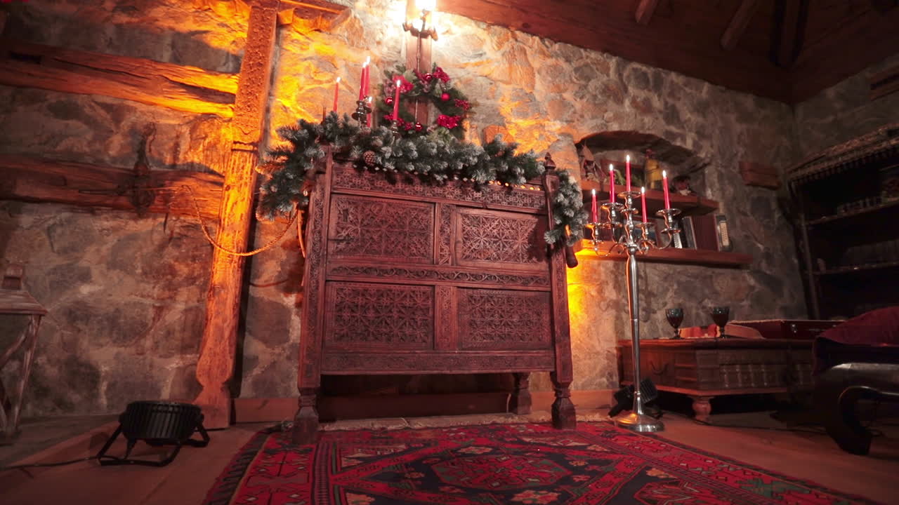 Stone walls and wooden elements in the interior of a country manor. Old fashion stylish furniture with decorations for Christmas.