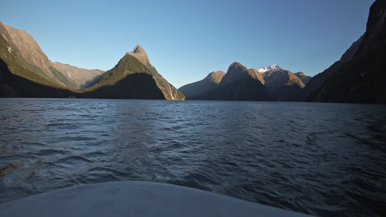 Vidvinkelvy av kryssningen på Milford Sound i Nya Zeeland. Utsikt över bergen i fjärran, havet i förgrunden