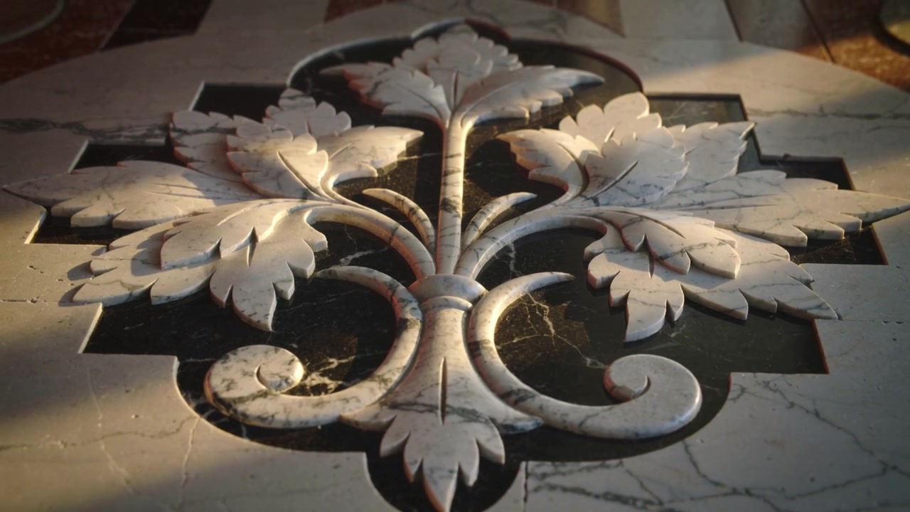 Telecamera in movimento che mostra un medaglione floreale in marmo intagliato nell'atrio, con la luce che cambia e rivela le venature.