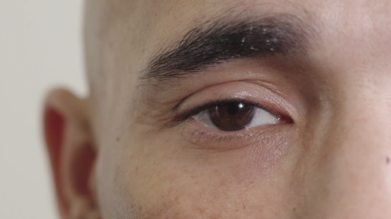 히스패닉 남자의 가까운 눈 카메라를 바라보며  ⁇ 박이는 성찰적 반사 비전 시력