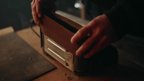 putting a paper sanding belt on an electric belt grinder