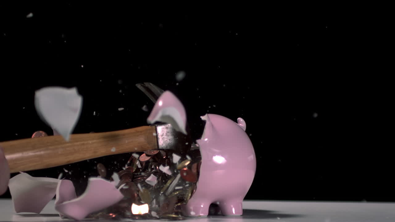 un martillo rompiendo una alcancía