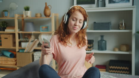 woman listening to music on smartphone at home