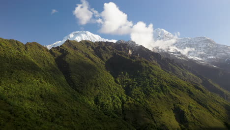 epic aerial drone shot of the sun shining on the side of the annapurna mountains, nepal