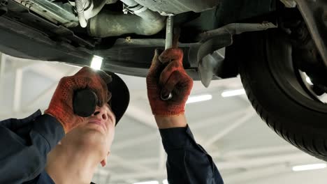 car mechanic working under a car