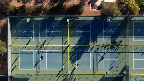 Vista-Aérea-De-Arriba-Hacia-Abajo-Gente-Jugando-Pickleball-En-Canchas-Deportivas-Al-Aire-Libre