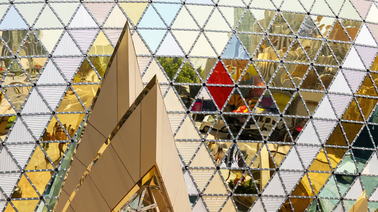 Facciata di edificio moderno con pannelli riflettenti geometrici.