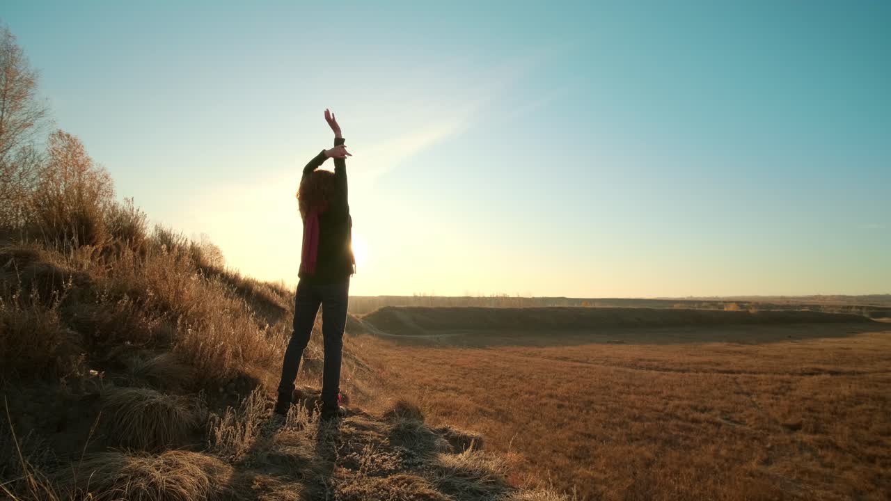 Woman enjoying sunrise on a hill
