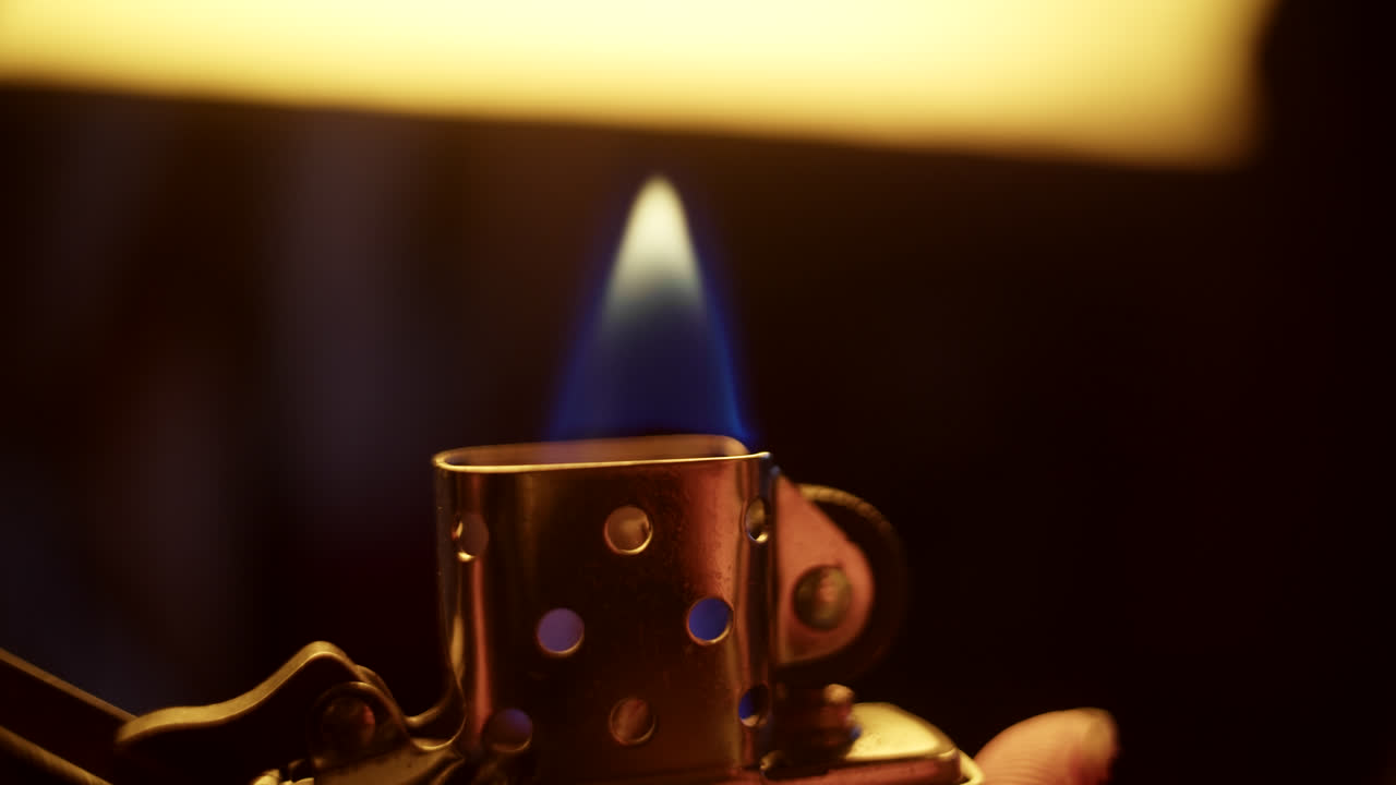 Close-up of a vintage lighter with a blue flame