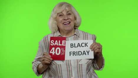 Senior-grandmother-showing-Black-Friday,-40-Percent-Off-discount-advertisement-banners.-Chroma-key