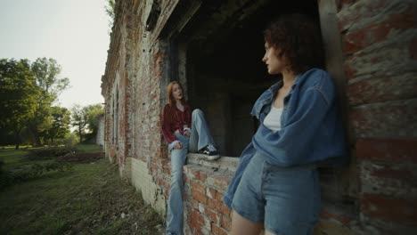 dos mujeres jóvenes posando en un edificio abandonado