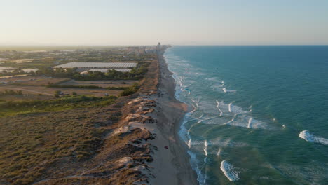 Luftaufnahme-Der-Küste-Am-Strand-Von-Mareny-Mit-Kitesurf-Drachen-Während-Des-Sonnenuntergangs-Valencia,-Spanien