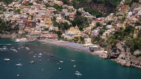 drone flying away from positano beach - top tourist attraction on amalfi coast, italy