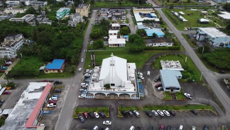 Low-level-drone-flyover-church,-buildings-and-roads-around-city