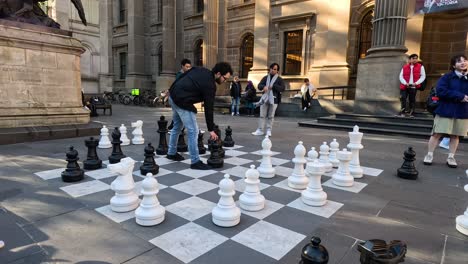 people playing giant chess in public square