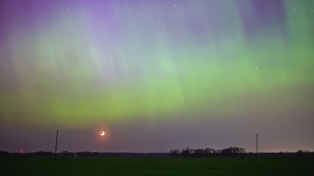 la aurora boreal ilumina el cielo nocturno cuando la luna creciente se pone debajo del horizonte - lapso de tiempo
