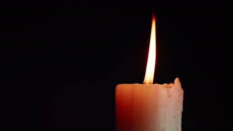 the showcases of colorful single candlelight on black background with the effect of light and slow motion