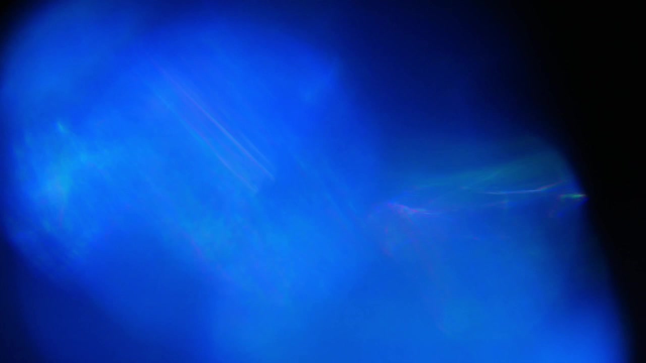 Fughe di luce blu dinamiche e bagliori dell'obiettivo su sfondo nero