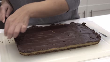 a mother examines the finished millionaire shortbread cookie on a cutting board