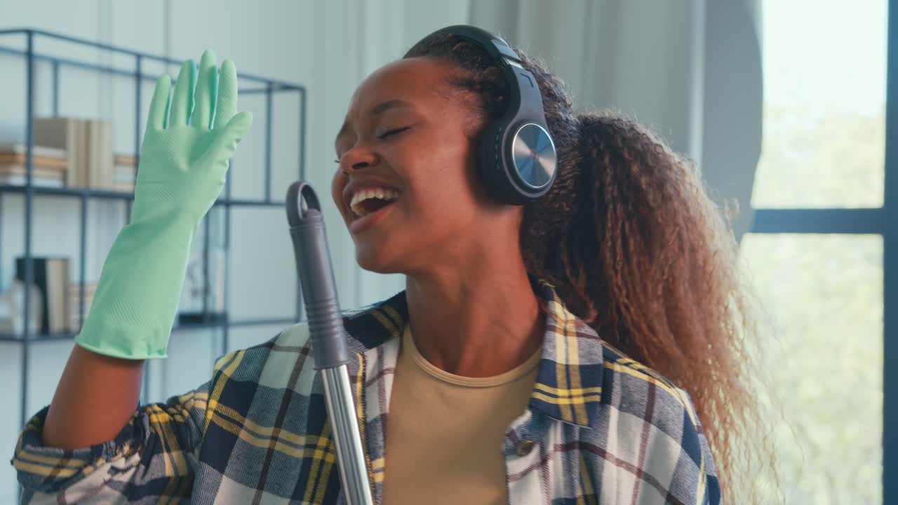 Momenti gioiosi mentre si pulisce casa con musica in un ambiente soleggiato.