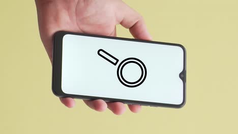 hand holding a phone in which a search magnifying glass animation appears on the screen