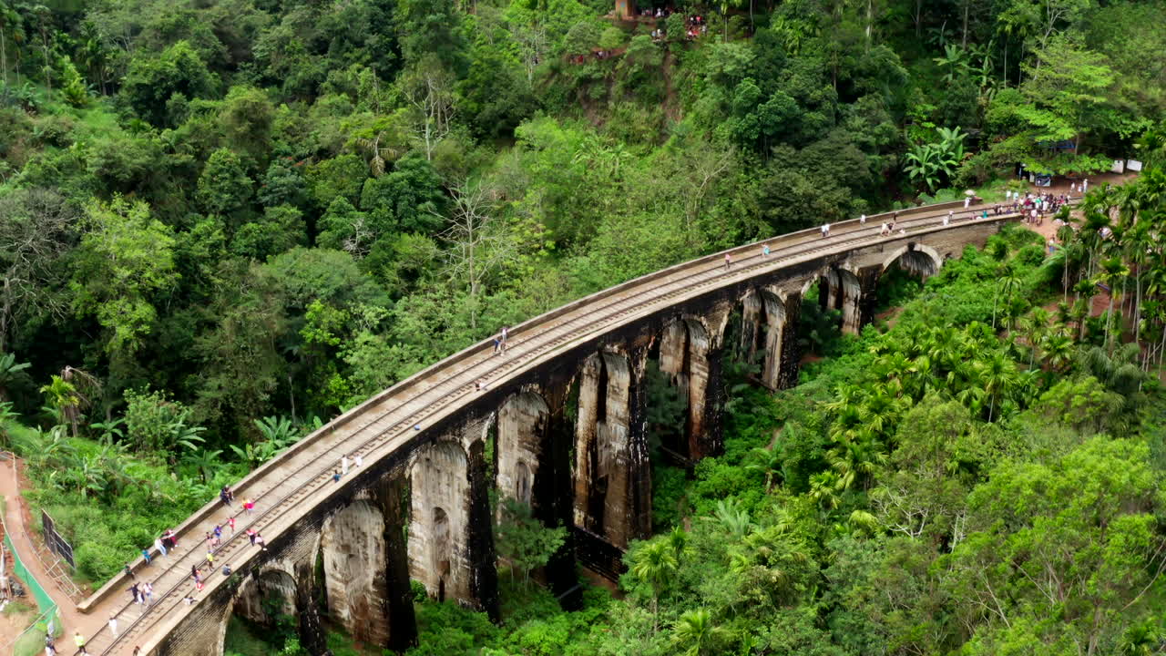 Slow drone flyby capturing the iconic Nine Arches Bridge near Ella, Sri Lanka, surrounded by dense jungle