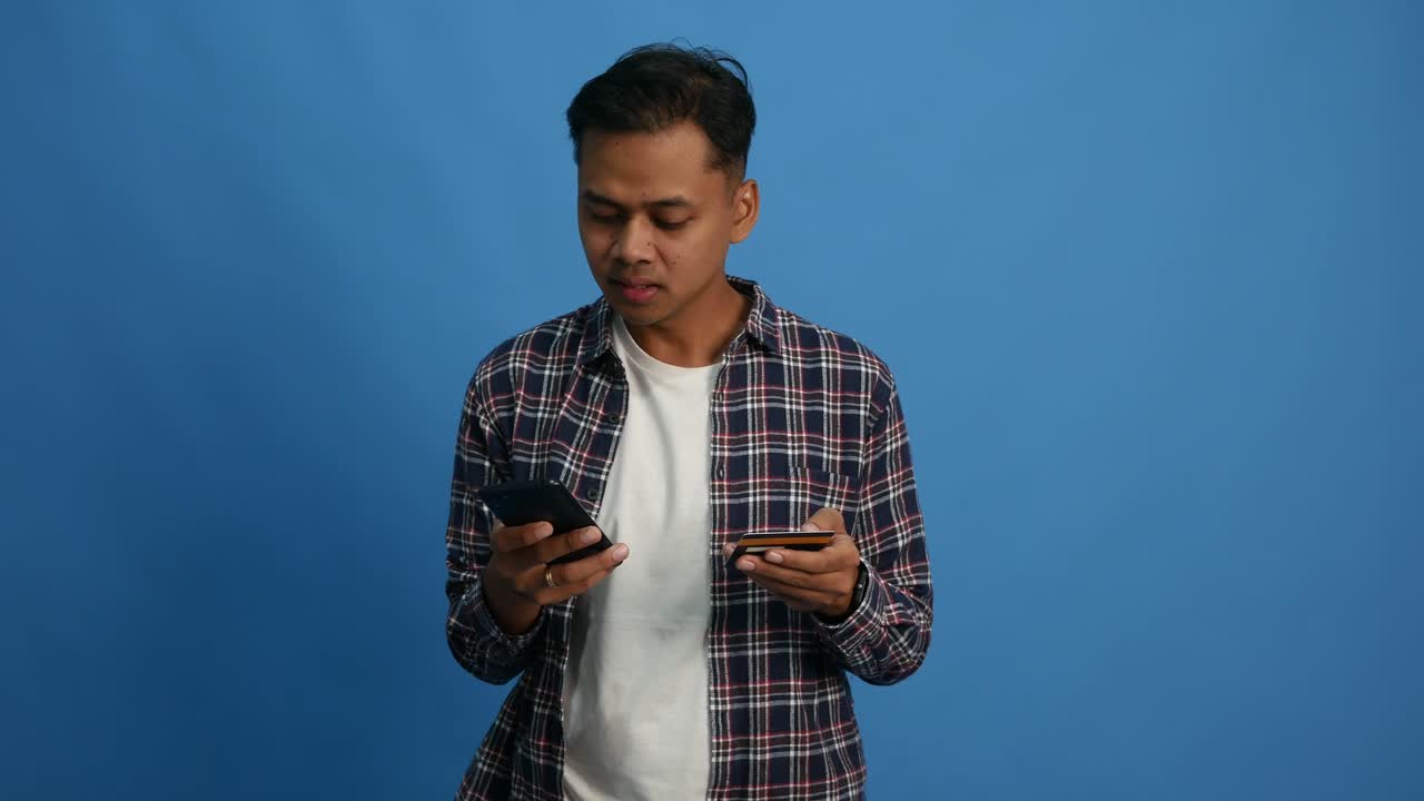 Happy Asian man, hands and phone with credit card for payment, online shopping or transaction. male person or shopper on mobile smartphone with debit for ecommerce