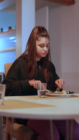 young woman eating dinner