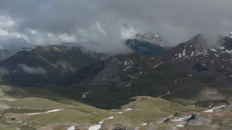 Antenne-Eines-Atemberaubenden-Grünen-Tals-Mit-Dunklen-Wolken,-Die-Sich-Am-Himmel-Bilden