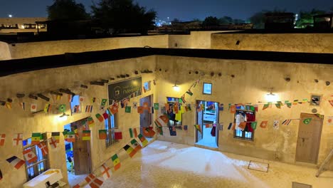 wide view of old town from the roof top of a traditional designed house in doha qatar decoration of the yard by colorful flags warm light clean and safe to welcome tourists all around the world cup