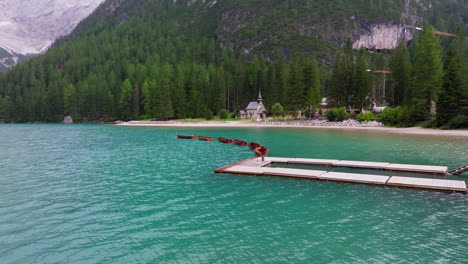 boats lined up to floating dock on clear braies lake in dolomites, tranquil waters below