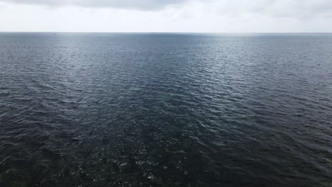 drone volando rápido sobre la superficie del agua azul, paisaje marino claro