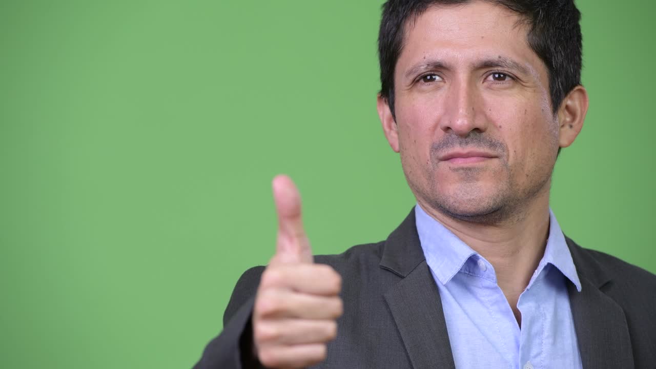 Happy Hispanic businessman giving thumbs up
