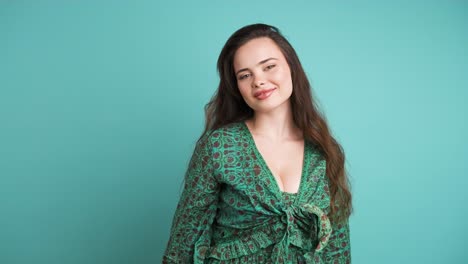 Beautiful woman smiling at camera in blue studio