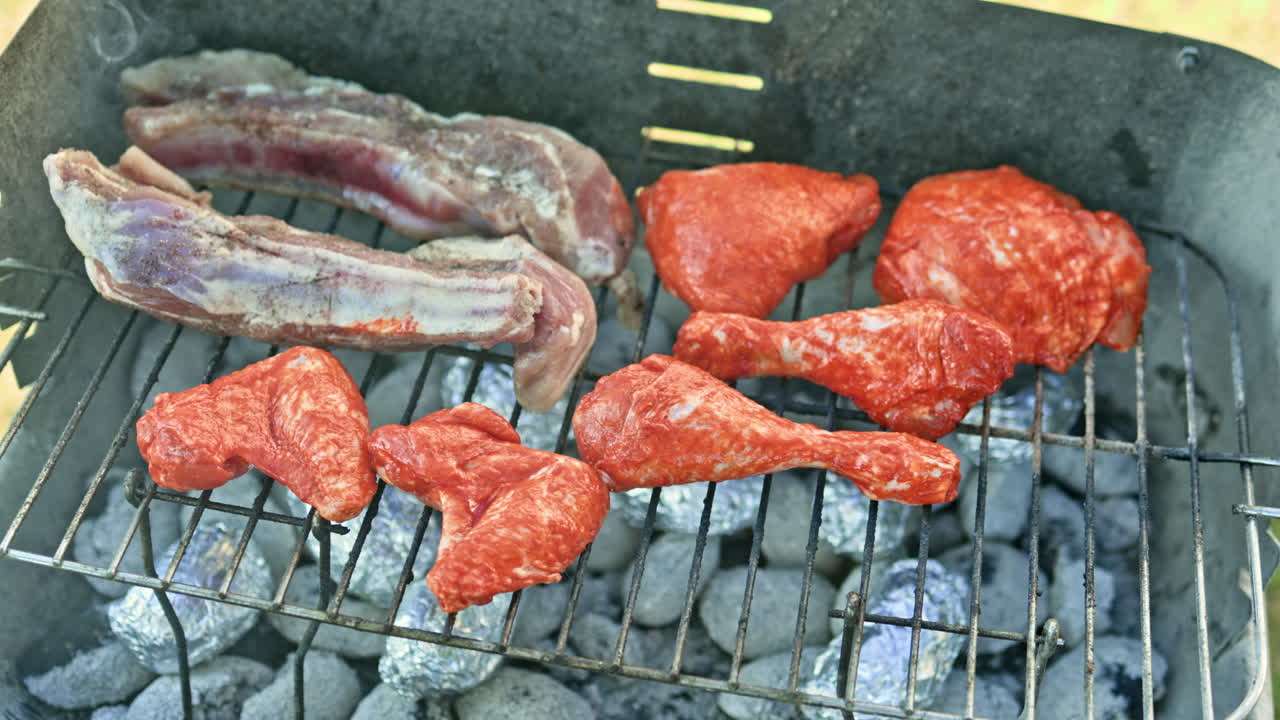 Daging marinasi segar dipanggang di atas panggangan barbekyu di jalanan. Bara arang untuk memanggang daging diletakkan di dalam panggangan, lalu steak ditaruh di atasnya. Barbekyu di halaman belakang rumah.