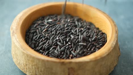 close-up of black rice in a wooden bowl