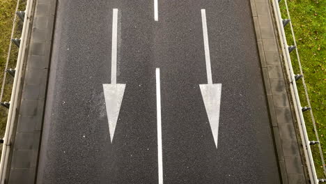 car changing from right lane to the left lane on a black asphalt equipped with white arrows to guide the vehicles in gdynia