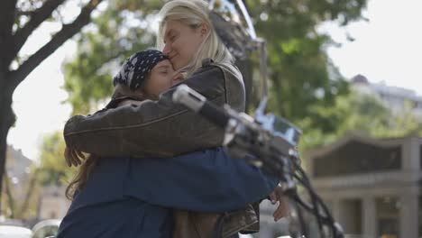 two young lesbians having fun mounted on the motorcycle in the city