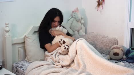 una chica deprimida lanza su oso de peluche