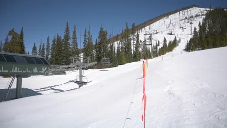 Ski-lift-carrying-skiers-and-snowboarders-up-ski-run,-timelapse