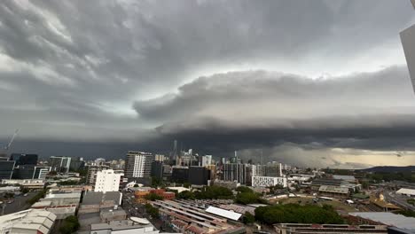 handheld motion time-lapse shot capturing dense dark layer of thunderstorm clouds covering the sky in brisbane city, south-east queensland, flash flood and severe weather warning, soaking wet season