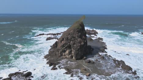 aerial orbitign shot of watu lumbung beach with crashing waves of ocean at sunny day, java indonesia