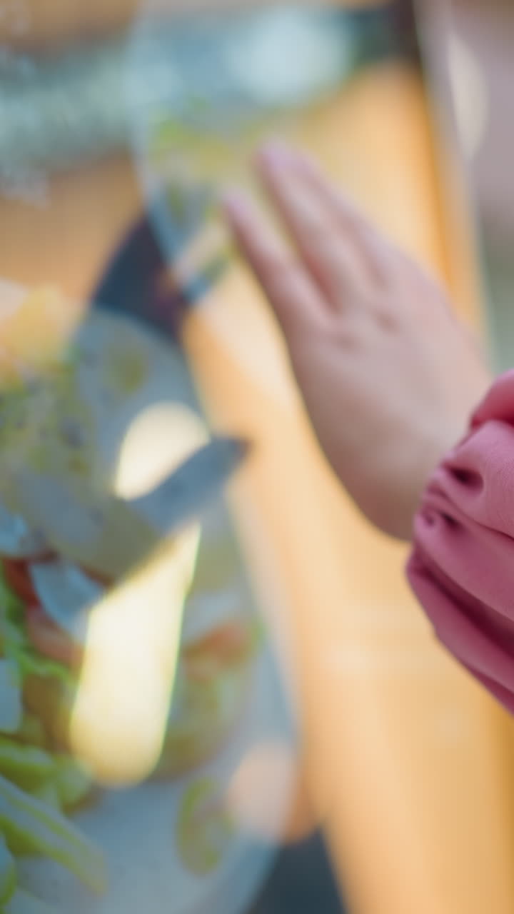 vista a mano de una dama con camisa rosa interactuando con una máquina de pantalla táctil en un centro comercial bien iluminado, la pantalla muestra contenido cambiante, mientras que otros elementos y elementos de fondo están ligeramente borrosos