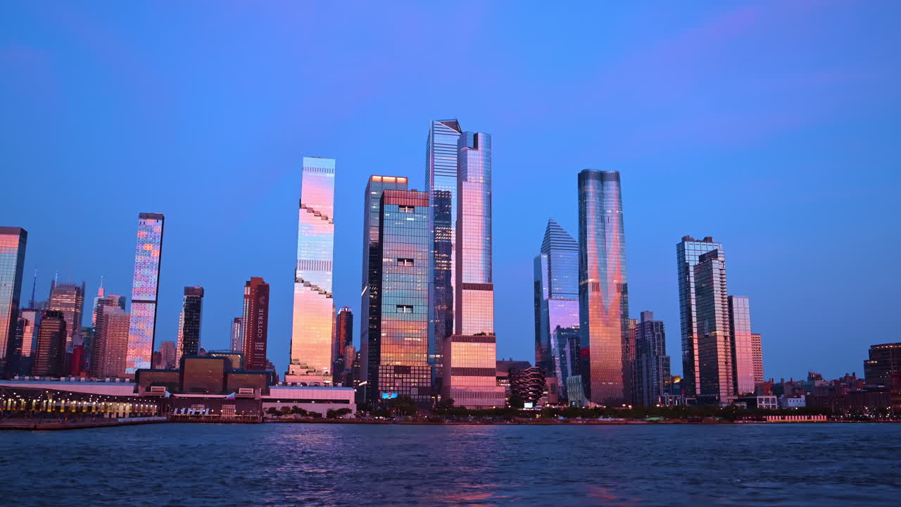 New York, USA, 8 August 2025: View of skyscrapers in New York skyline during sunset across the river. Skyscrapers in New York reflect colors of sunset over the river