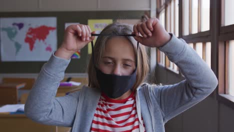 Niña-Con-Mascarilla-En-La-Clase-De-La-Escuela