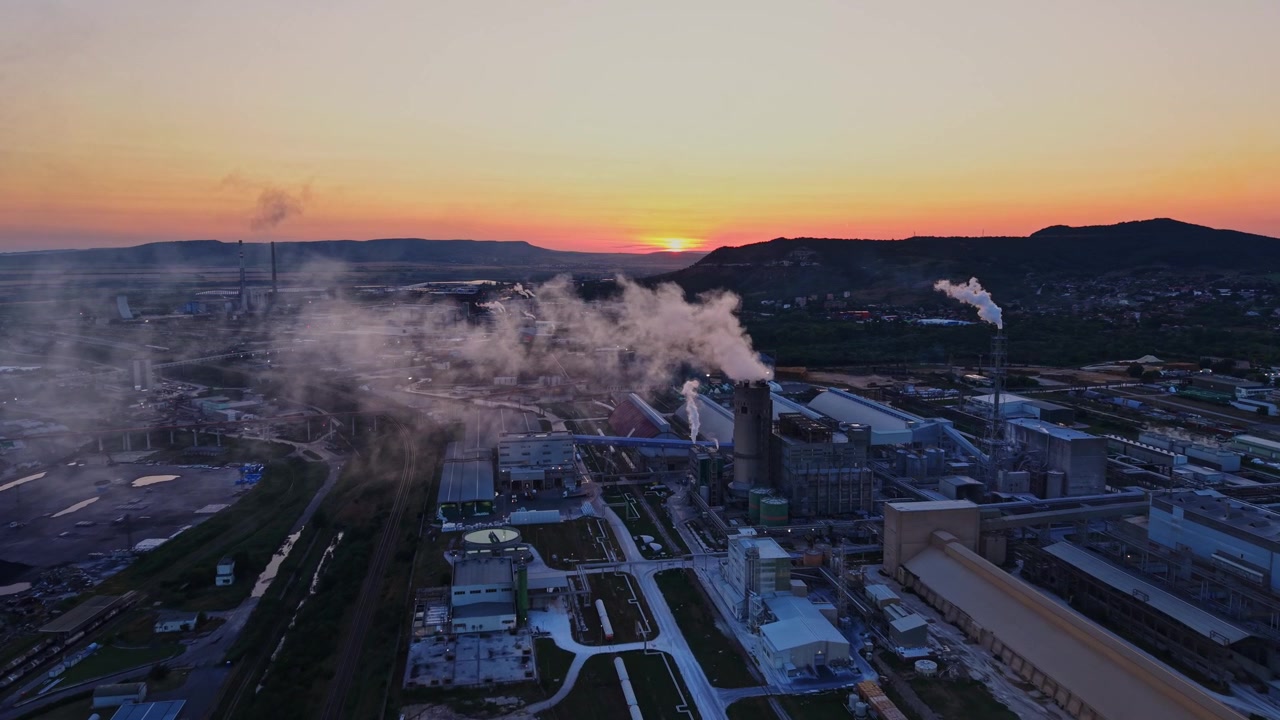 Scena di fabbrica con fumo e tramonto su un'area industriale