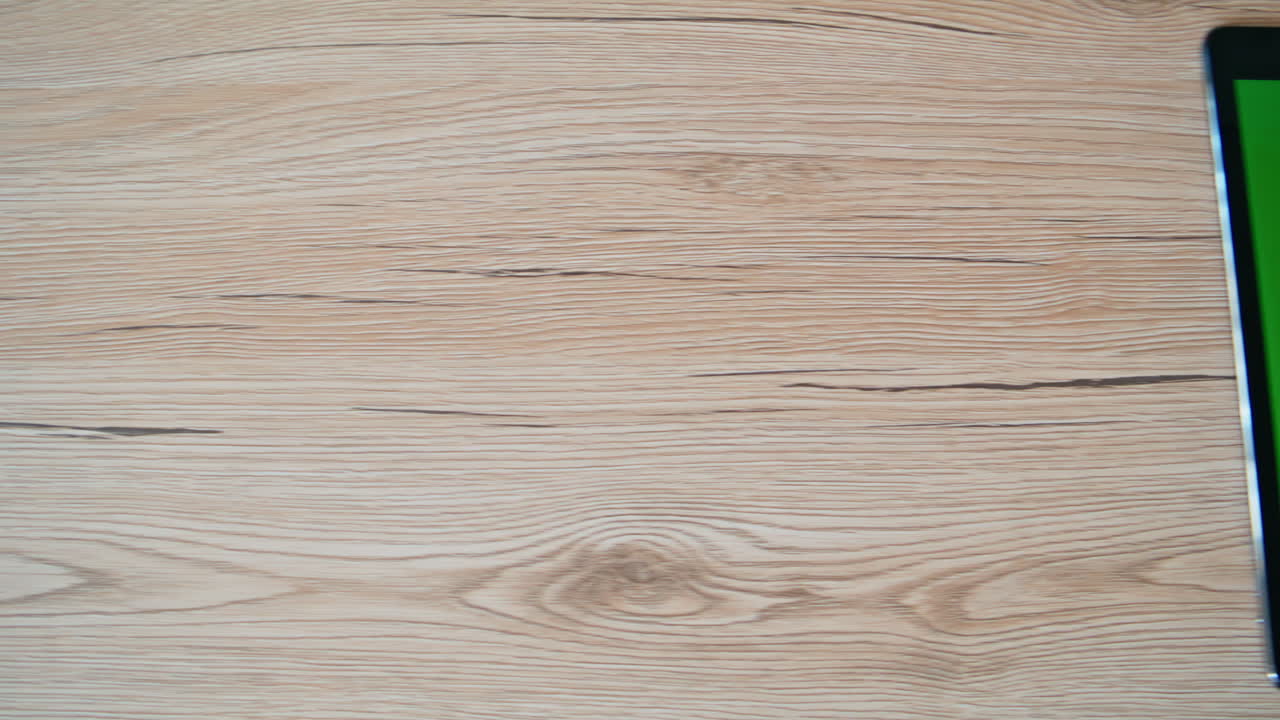 Slide chroma key tablet lying on wooden desk closeup. Green screen pad computer