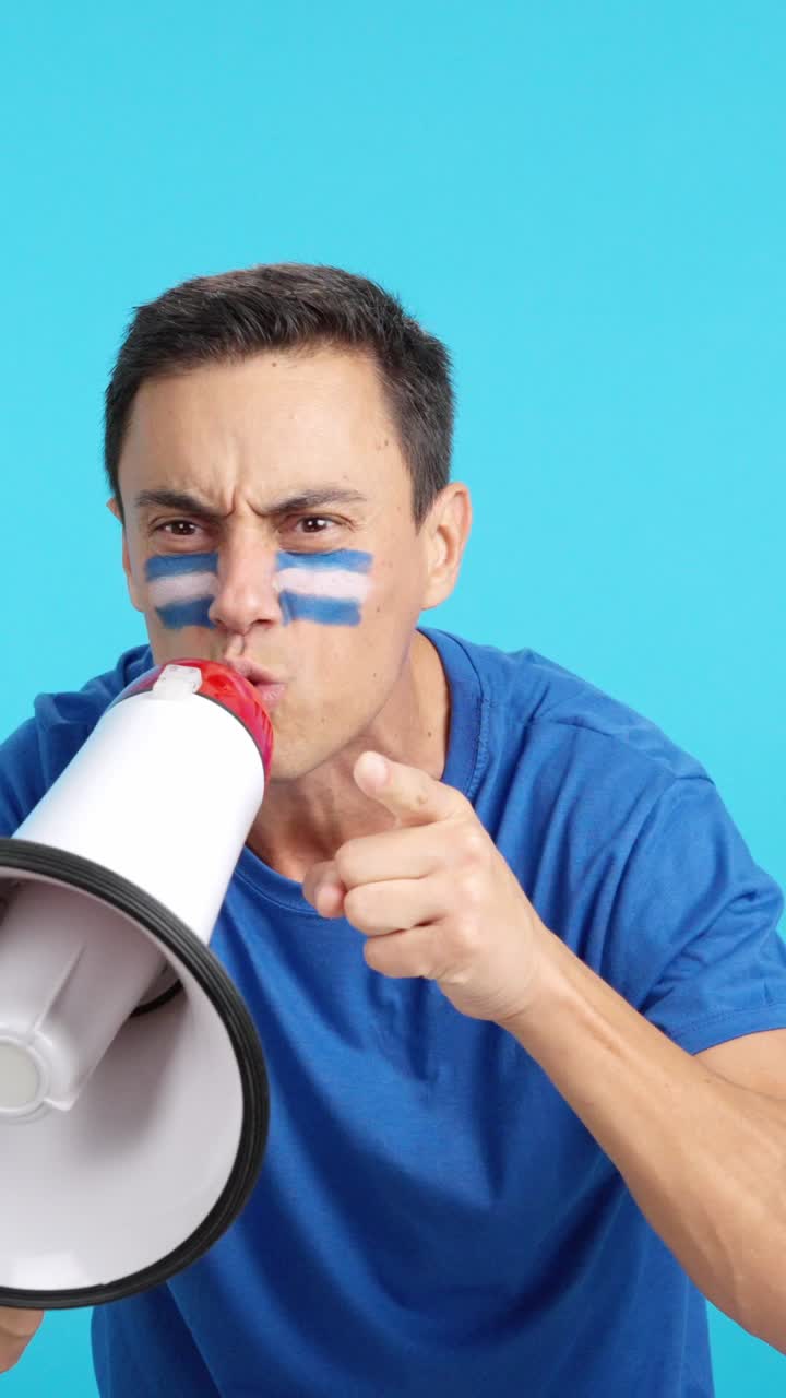 Excited man with salvadoran flag on face using a megaphone